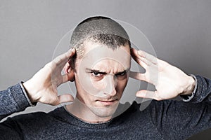 Young man plugging ears to avoid listening to problems