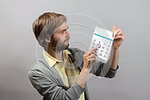 Young man pointing the date on the calendar