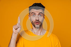 Young man pointing finger up at copy space isolated