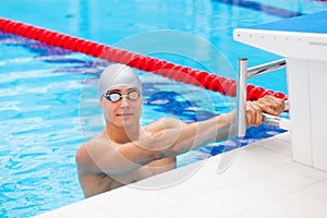 Young man in a pool - go to start swimming. backstroke during