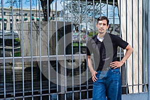 Young man posing in front of modern architecture