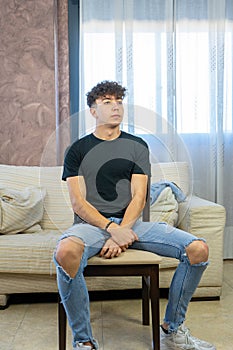 Young man posing on a living room sofa