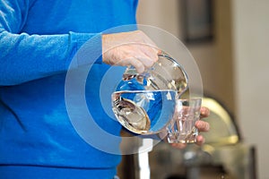 Young man pouring himself water