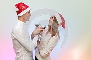 Young man pouring wine into glasses to his girlfriend. Valentine`s celebration concept
