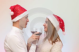 Young man pouring wine into glasses to his girlfriend. Valentine`s celebration concept