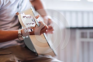 A young man is practicing playing guitar in a music practice room before performing in order to reduce the mistake of playing