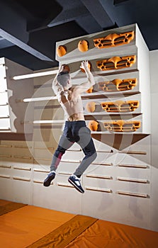 Young man practicing rock-climbing in climbing gym