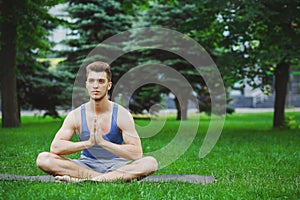 Young man practicing yoga sitting in padmasana