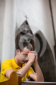 Young man praying in a church