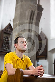 Young man praying in a church