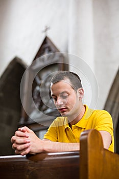 Young man praying in a church