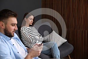 Young man preferring smartphone over his girlfriend. Relationship problems