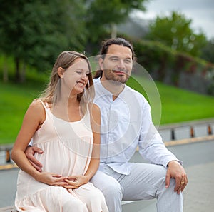 A young man and a pregnant woman in bright clothes