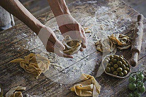 The young man prepares homemade pasta at rustic kitchen