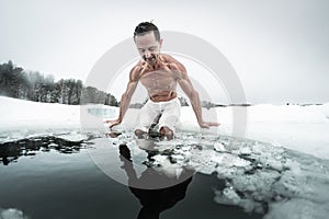 Young man prepares to swim in the ice hole