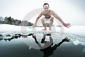 Young man prepares to swim in the ice hole