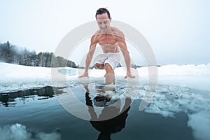 Young man prepares to swim in the ice hole