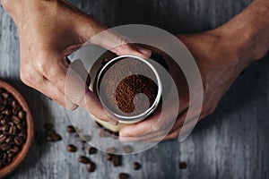 Young man is preparing coffee in a moka pot photo