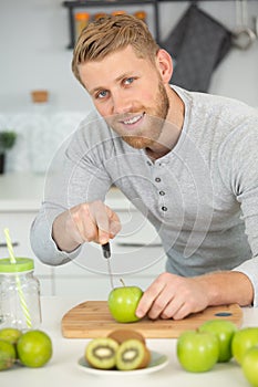 young man preparing fresh fruit juice