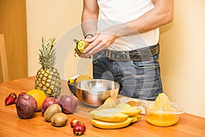 Young man preparing a fruit salad or smoothie
