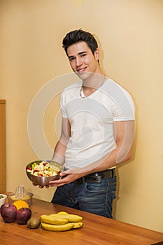 Young man preparing a fruit salad or smoothie
