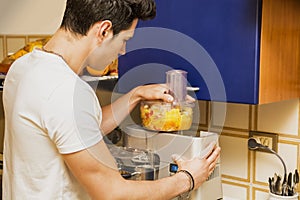 Young man preparing healthy fruit smoothie