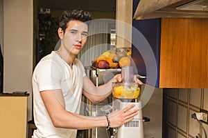 Young man preparing healthy fruit smoothie