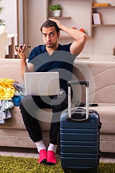 Young man preparing for journey at home