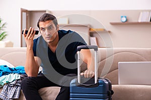 Young man preparing for journey at home