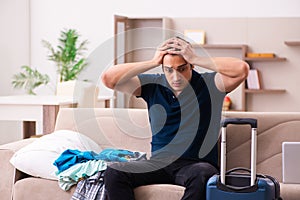 Young man preparing for journey at home