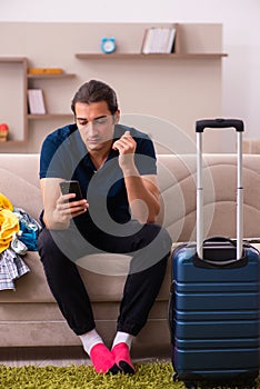 Young man preparing for journey at home