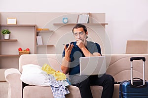 Young man preparing for journey at home