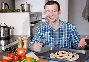 Young man preparing pizza