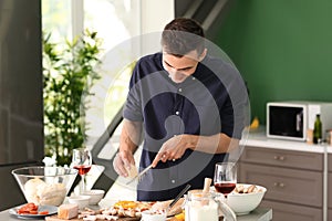 Young man preparing pizza in kitchen