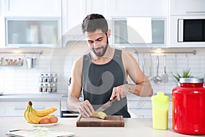 Young man preparing protein shake at table