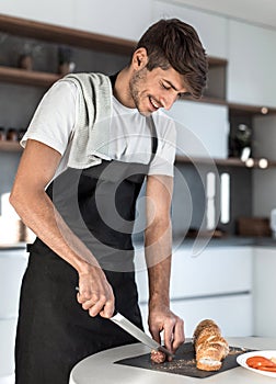 Young man preparing a sandwich in the kitchen