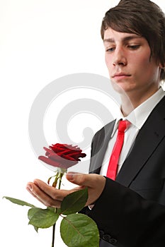 Young man presenting a flower red rose isolated