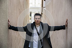 Young man pressed between two walls. Oppression, anxiety