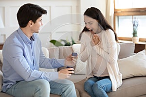 Young man propose with diamond ring to excited woman