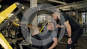 Young man with prosthetic leg using leg press machine in gym