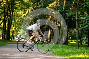 Young man in protective hemlet on a bike in the park