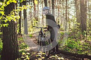 Young man in protective mask from environmental pollution riding mountain bike on cross country road. Cyclist Riding the Bike on