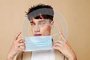 A young man protective mask in hand in hand modern style light background unaltered