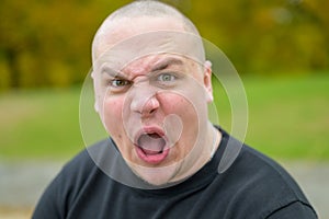 Young man pulling a menacing ugly face photo