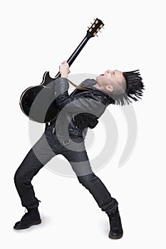 Young man with punk Mohawk playing guitar photo