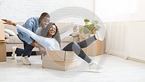 Young man pushing box with his woman, moving in