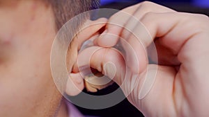 A young man puts on a digital hearing aid. Fourth degree hearing loss. Bilateral sensorineural hearing loss