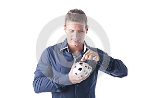 Young man putting coin in piggy-bank, isolated