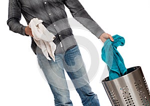 Young man putting a dirty towel in a laundry basket