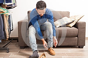 Young man putting shoes on in dressing room